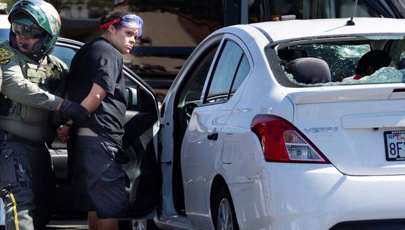 Una mujer no identificada es detenida después de que testigos dijeron que condujo su automóvil contra una multitud de manifestantes en Yorba Linda, California. (AP/Mindy Schauer/The Orange County Register).