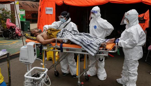 Trabajadores de la salud tratan a un hombre que sufre de coronavirus COVID-19 fuera de una carpa de emergencia instalada en un estacionamiento en un hospital en Bekasi, Java Occidental, Indonesia, el 28 de junio de 2021. (EFE / EPA / MAST IRHAM).