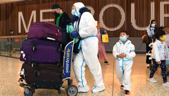 Viajeros internacionales que usan equipo de protección personal (PPE) llegan al aeropuerto Tullamarine de Melbourne. (Foto: William WEST / AFP)