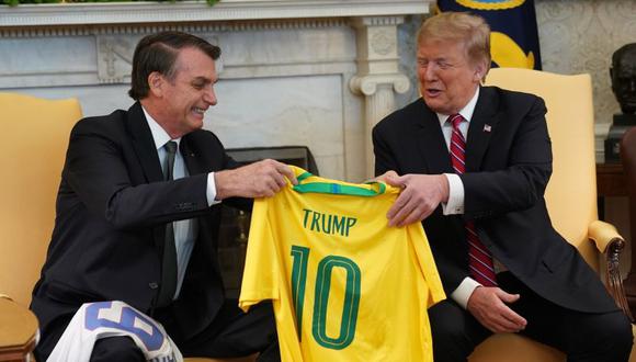 Trump y Bolsonaro intercambian camisetas de fútbol con sus nombres. (Foto: EFE)
