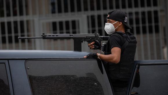 Un policía de las Fuerzas de Acciones Especiales (FAES) de la Policía Nacional Bolivariana viaja en una patrulla para entrar al barrio Cota 905 este viernes, en Caracas (Venezuela). (EFE/RAYNER PEÑA R.).