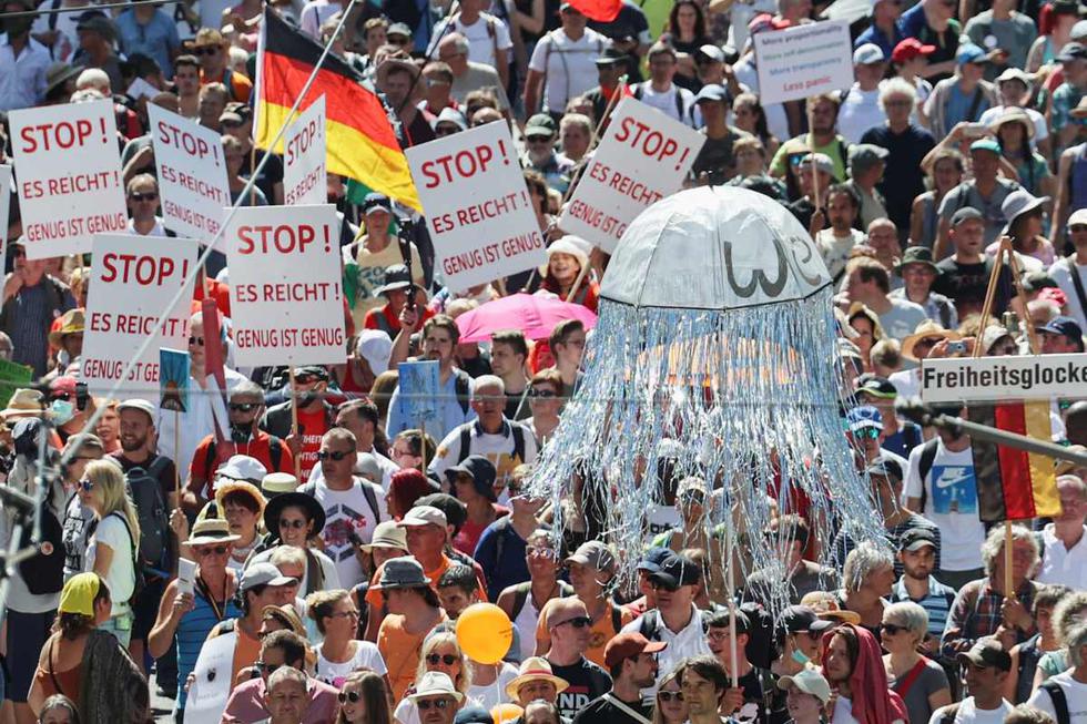 Los manifestantes sostienen pancartas durante una protesta contra las restricciones del gobierno en medio del brote del coronavirus (COVID-19), en Berlín, Alemania  (REUTERS/Fabrizio Bensch).