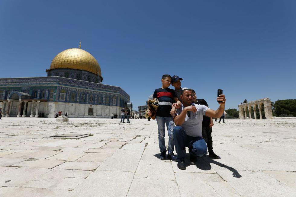 Una familia se toma un selfie junto a la mezquita al-Aqsa en el complejo conocido por los musulmanes como el Santuario Noble, y los judíos como el Monte del Templo, ya que reabrió a los fieles después de un cierre de más de dos meses debido al brote del coronavirus, en la Ciudad Vieja de Jerusalén.  (REUTERS/Ammar Awad)