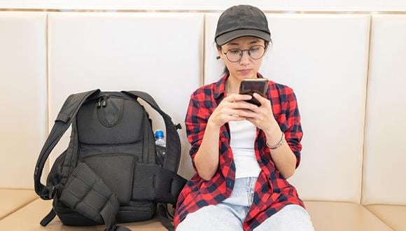 Young female traveler using cell phone
