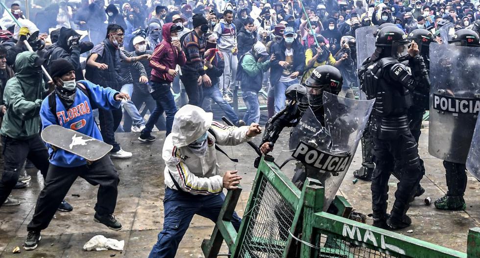 Manifestantes chocan con la policía antidisturbios durante una protesta contra un proyecto de reforma tributaria lanzado por el presidente colombiano Iván Duque, en Bogotá, el 28 de abril de 2021. (Juan BARRETO / AFP).