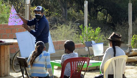 Un profesor en Cochabamba da clases en la casa de unos niños. (AFP)