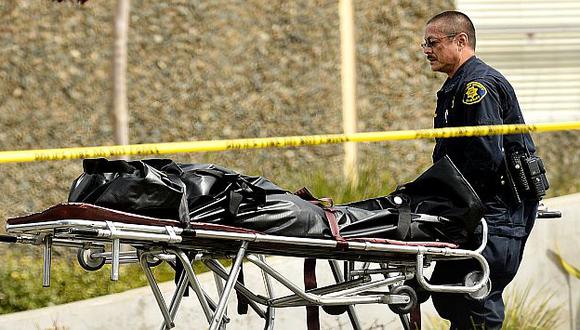 Un agente retira uno de los cadáveres de campus universitario. (AP)