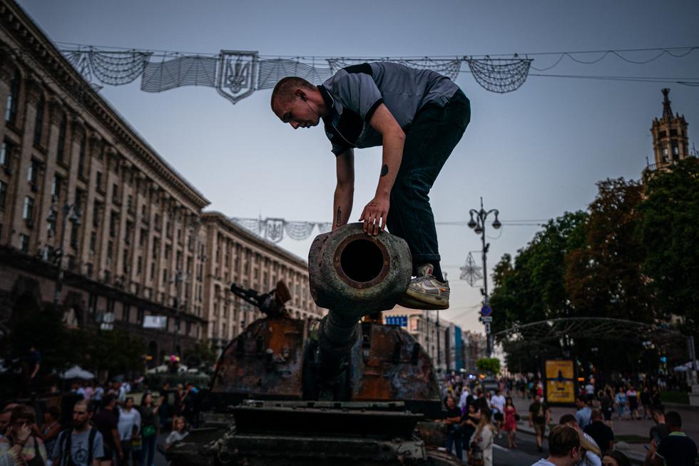 En esta fotografía  un hombre se sube a un tanque ruso destruido en la calle Khreshchatyk en Kyiv, que se ha convertido en un museo militar al aire libre en el Día de la Independencia de Ucrania el 24 de agosto. (Texto: AFP / Foto:  Dimitar DILKOFF / AFP)