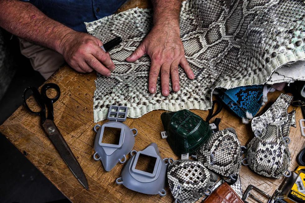 Brian Wood hace máscaras faciales de piel de serpiente dentro de su taller en Delray Beach, a unas 52 millas al norte de Miami, el 21 de mayo de 2020. (AFP / CHANDAN KHANNA).