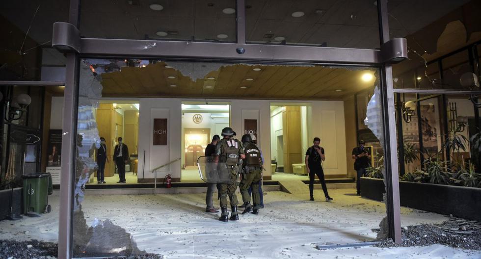 Los policías permanecen en la entrada del Hotel O'Higgins después de que su fachada fue destruida por manifestantes. (Foto. EFE)