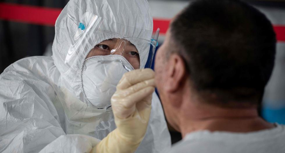 Imagen referencial. Un trabajador de la salud realiza una prueba de hisopo a un hombre en un área al aire libre en Beijing (China). (AFP / NICOLAS ASFOURI).