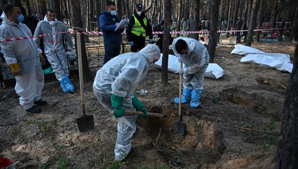 Los forenses desentierran cuerpos en un bosque cerca de Izyum, en el este de Ucrania, el 19 de septiembre de 2022. (Foto: SERGEY BOBOK / AFP)