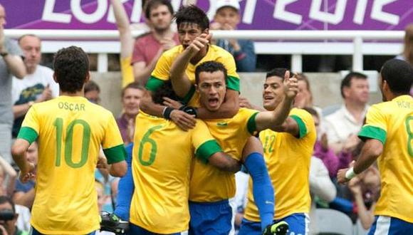 BUSCAN LA GLORIA. Leandro Damiao y Romulo celebran tras la victoria brasileña. ()