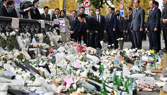 El presidente de Corea del Sur, Yoon Suk-yeol, mira los mensajes de los dolientes en un memorial improvisado para las víctimas del mortal aumento de la multitud de Halloween, afuera de una estación de metro en el distrito de Itaewon en Seúl el 1 de noviembre de 2022. (Foto de Jung Yeon-je / AFP)