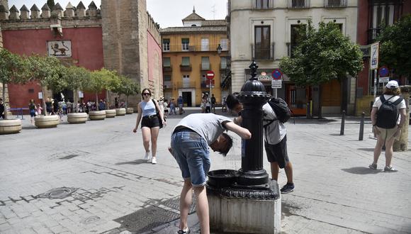 La gente se refresca para combatir el calor abrasador durante una ola de calor en Sevilla el 13 de junio de 2022.  (Foto por CRISTINA QUICLER / AFP)
