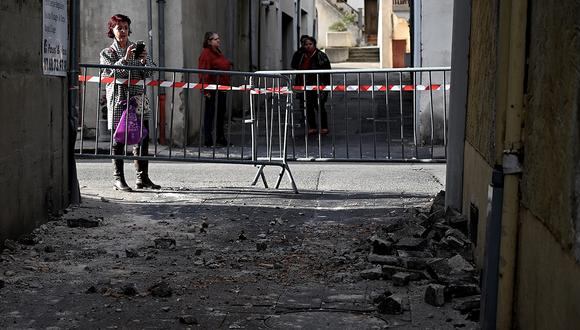 Una mujer toma una foto de ladrillos que se cayeron de una pared en Le Teil, en el sureste de Francia, el 11 de noviembre de 2019, después de un sismo de 5,4 grados de magnitud en el área. (Foto: AFP)