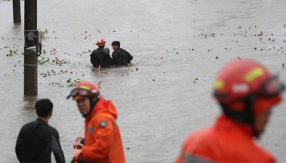 Rescatistas de Corea del Sur rescatan a un hombre de un parque ribereño inundado en Ulsan el 6 de septiembre de 2022, cuando el tifón Hinnamnor azotó las provincias del sur de Corea del Sur. (Foto de YONHAP / AFP)