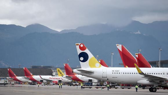 Un avión de Viva se ve entre aeronaves de Avianca en el Aeropuerto Internacional El Dorado de Bogotá, el 14 de mayo de 2022. (Foto de DANIEL MUNOZ / AFP)