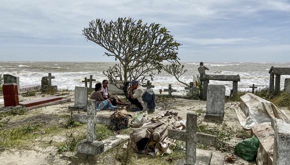Familiares se sientan junto a los cuerpos exhumados de las tumbas destruidas por el ciclón Batsirai en el cementerio local de Mahanoro el 6 de febrero de 2022. (Foto: Laure Verneau / AFP)