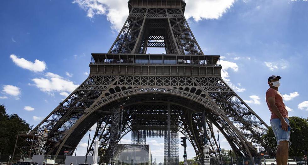 Un hombre con una máscara protectora camina cerca de la Torre Eiffel, en París, Francia, el 27 de agosto de 2020. (EFE/EPA/IAN LANGSDON).