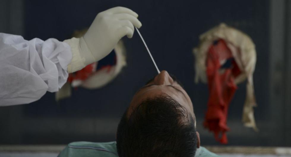 Un trabajador de la salud recolecta un hisopo nasal para una prueba RT PCR de coronavirus Covid-19 en el Hospital y Facultad de Medicina del Norte de Bengala, India. (Foto de Diptendu DUTTA / AFP).