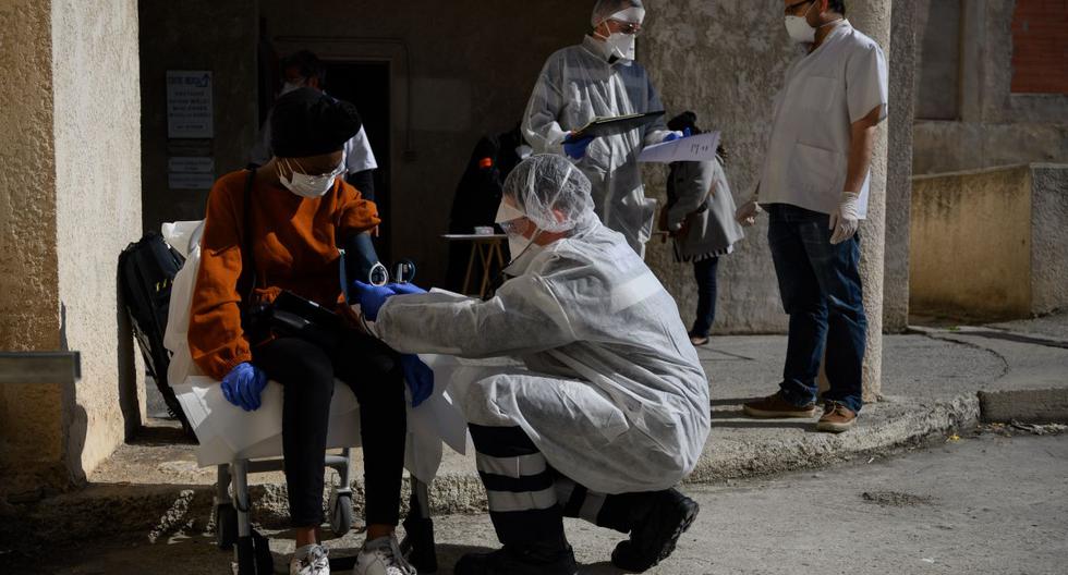 Bomberos franceses de Marins-Pompiers de Marsella con equipos de protección examinan a una mujer de 19 años, sospechosa de estar infectada con el nuevo coronavirus. (AFP/CHRISTOPHE SIMON).
