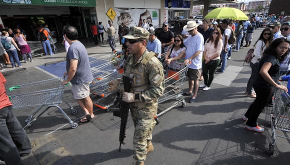 MIEDO Y PREVISIÓN. Chilenos hacen largas filas en supermercados para abastecerse de alimentos. (AFP)