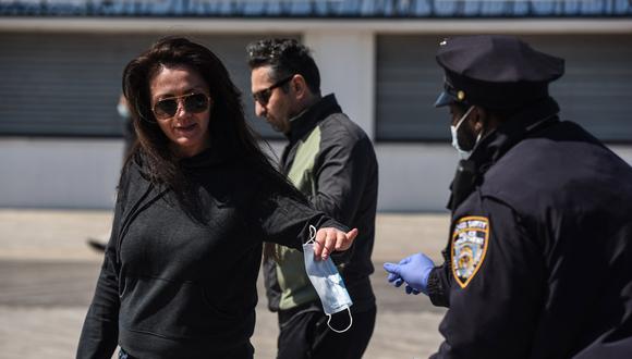 Una persona recibe una máscara protectora de un miembro del departamento de policía de la ciudad de Nueva York en el vecindario de Coney Island en el distrito de Brooklyn. (Foto: AFP/Stephanie Keith)