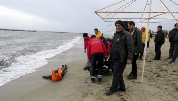 Voluntarios retiran el cadáver de una mujer que trataba de llegar a Grecia desde la costa de Turquía. (EFE)