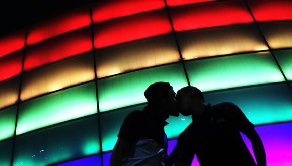 Camilo Barato y Cristian Toquica besan el Movistar Arena coloreado con la bandera del arcoíris durante el Día Internacional del Orgullo LGBTIQ en Bogotá, Colombia, el 28 de junio de 2021. (Foto de DANIEL MUNOZ / AFP)