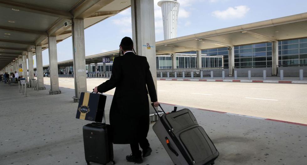Un pasajero que sale hace rodar sus maletas en el aeropuerto Ben Gurion casi desierto en Lod, cerca de la ciudad costera israelí de Tel Aviv, el 13 de mayo de 2021. (GIL COHEN-MAGEN / AFP).