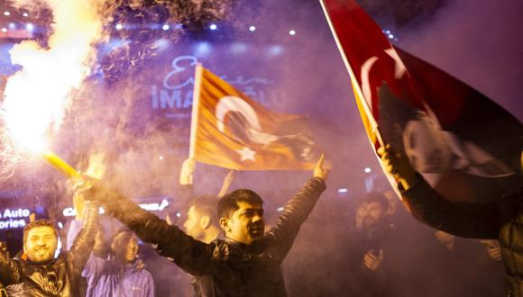 Partidarios de la principal oposición el Partido Popular Republicano ondean banderas y encienden antorchas para celebrar las elecciones locales en Estambul, Turquía. (Foto: AFP)