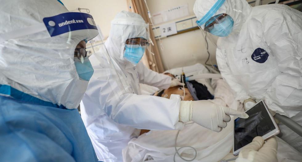 Un grupo de doctores revisan a un paciente en un hospital de Wuhan, ciudad epicentro del coronavirus y que se encuentra en cuarentena. (AFP)