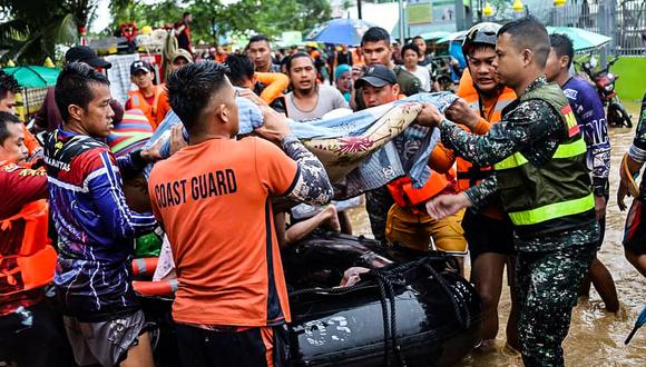 Rescatistas están evacuando a las personas de un área inundada debido a las fuertes lluvias provocadas por la tormenta tropical Nalgae en Parang, (Foto:  PHILIPPINE COAST GUARD  / AFP)