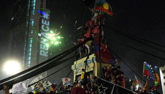 Miles de personas celebran en la Plaza Italia el triunfo del Apruebo en el histórico plebiscito en Chile. (EFE/ Alberto Valdes).