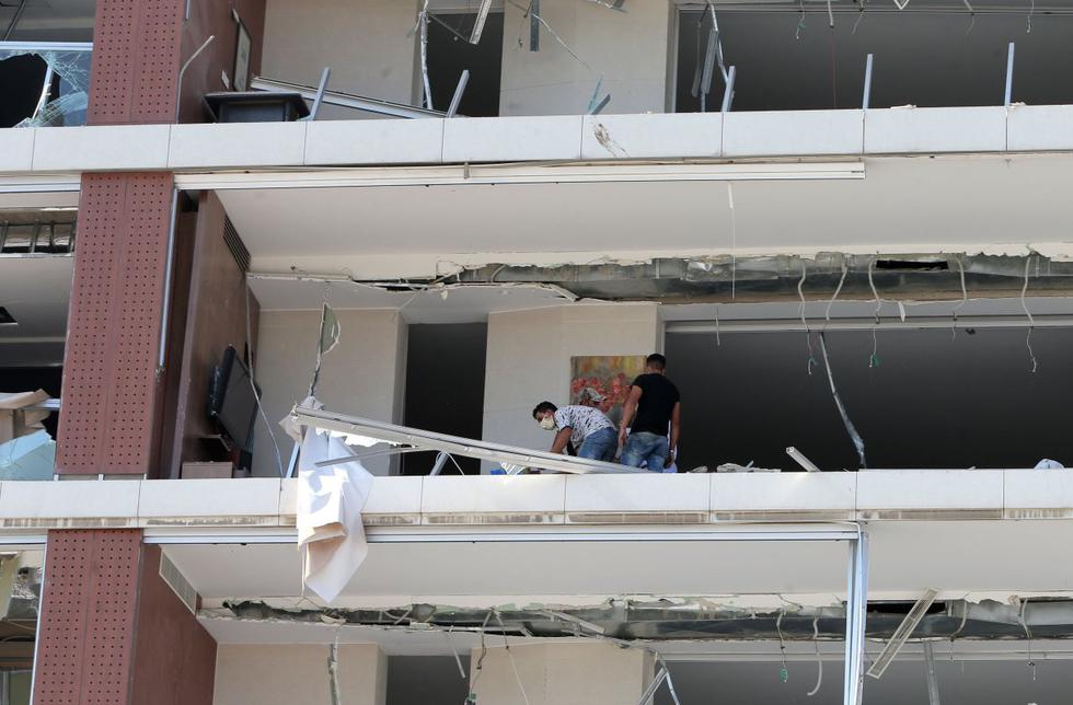 La gente inspecciona el daño este 5 de agosto de 2020 en uno de los edificios de Beirut (Líbano). (AFP / STR).
