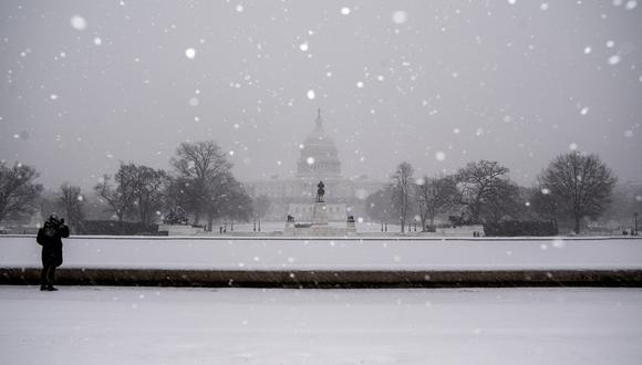 Un visitante toma una foto del Capitolio de los EE. UU. durante una tormenta invernal en Washington, DC, el 16 de enero de 2022. (Foto: Stefani Reynolds / AFP)