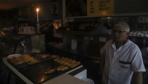 Foto referencial que muestra a un hombre trabajando a la luz de las velas en una panadería durante un corte de energía en Buenos Aires el 16 de junio de 2019. (Foto: Juan VARGAS / NOTICIAS ARGENTINAS / AFP)