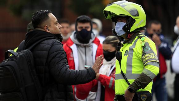 Imagen referencial. Un oficial de policía habla con un conductor en Bogotá. (Foto: AFP/DANIEL MUNOZ)