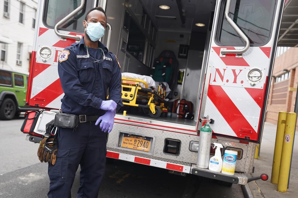 An FDNY paramedic puts on fresh gloves after bringing a patient to Wyckoff Hospital in the Bushwick section of Brooklyn April 5, 2020 in New York. - The coronavirus death toll in New York state spiked to 4,159, the governor said, up from 3,565 a day prior. The toll increase of 594 showed a slight decrease in the day-to-day number of lives lost compared to the previous day.  Governor Andrew Cuomo told journalists it was too soon to tell whether the decrease from the previous record of 630 deaths in one day was statisically significant. (Photo by Bryan R. Smith / AFP)