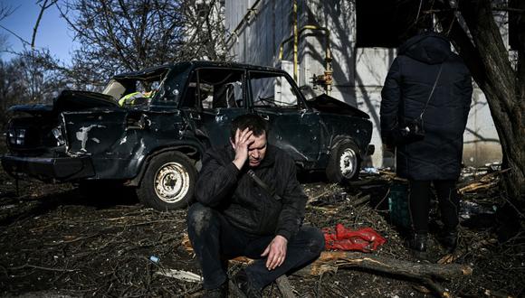Un hombre se sienta afuera de su edificio destruido después de los bombardeos en la ciudad de Chuguiv, en el este de Ucrania, el 24 de febrero de 2022. (ARIS MESSINIS / AFP).