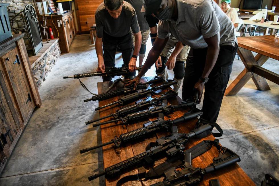 Las personas colocan sus rifles semiautomáticos AR-15 en un banco durante un curso de tiro en Boondocks Firearms Academy en Jackson, Mississippi. (AFP / CHANDAN KHANNA).