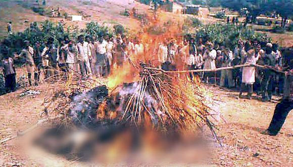Una gran multitud observa la escena en la que una mujer se quema hasta morir sentada en la pira funeraria de su marido cerca de la aldea de Tamoli, el 6 de agosto de 2002, en el estado central indio de Madhya Pradesh. (Foto: AFP)