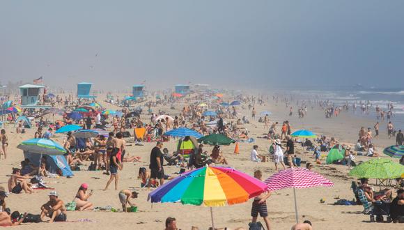 Imagen referencial. La gente disfruta de la playa en medio de la nueva pandemia de coronavirus en Huntington Beach, California, el 25 de abril de 2020.  (Apu GOMES / AFP).