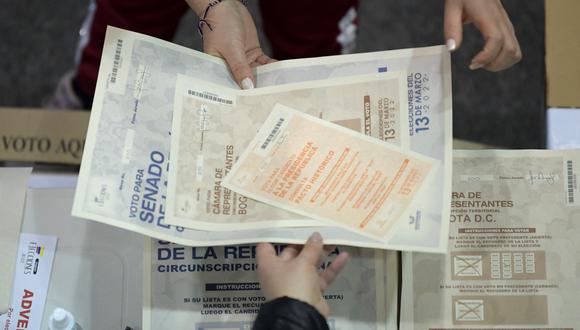 Una mujer revisa las listas antes de votar en un colegio electoral en Bogotá el 13 de marzo de 2022. (Foto: Raul ARBOLEDA / AFP)