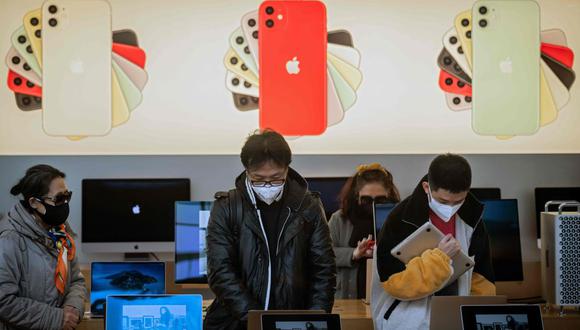 Los usuarios continuarán teniendo apoyo y soporte para sus dispositivos en internet. Clientes que usan mascarillas como medida preventiva contra el coronavirus se ven dentro de una tienda de Apple en Beijing. (AFP).