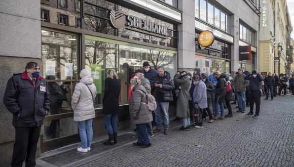 La gente hace cola frente a una sucursal del banco estatal ruso Sberbank para retirar sus ahorros y cerrar sus cuentas en Praga el 25 de febrero de 2022, antes de que Sberbank cierre todas sus sucursales en la República Checa ese mismo día. (Foto de Michal Cizek / AFP)