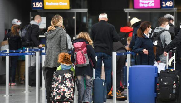 Pasajeros, entre ellos niños, hacen cola en el check-in para un vuelo a Mallorca en el nivel de salida del aeropuerto de Dusseldorf, en el oeste de Alemania, el 26 de marzo de 2021 (Foto: Ina FASSBENDER / AFP)