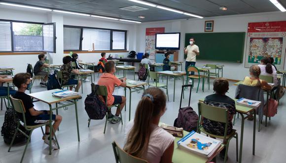 Un grupo de estudiantes españoles utilizan mascarillas y aplican la distancia social mientras asisten a su primer día de clases. (Foto de JOSE JORDAN / AFP).