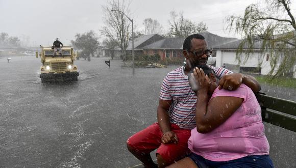 Las personas reaccionan cuando una lluvia repentina los empapa de agua en LaPlace, Louisiana, el 30 de agosto de 2021. (Patrick T. FALLON / AFP).